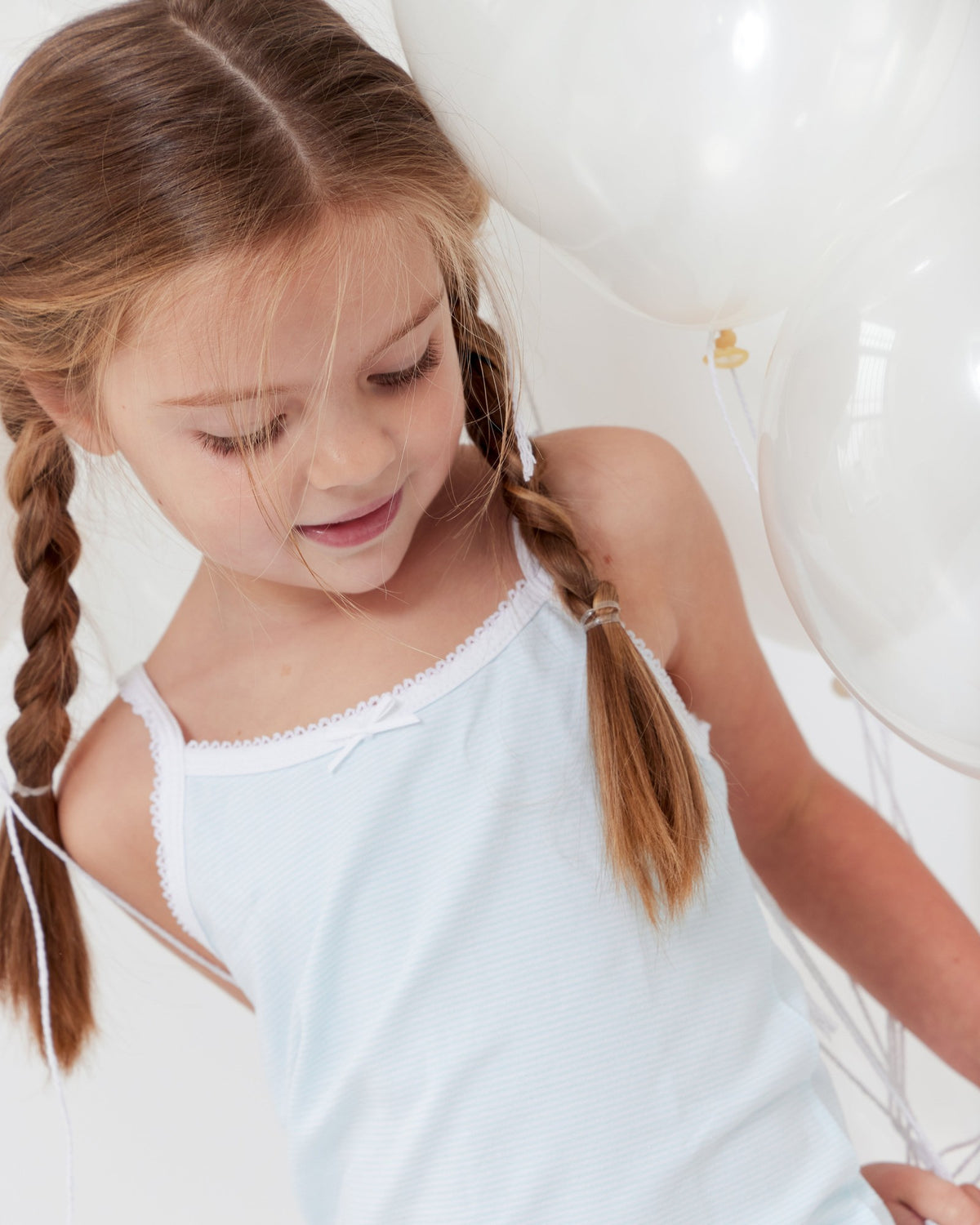 Girl with braids in a light blue Feathers camisole